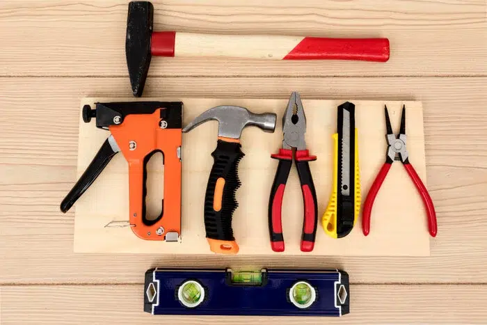 Assorted woodworking tools laid out on a wooden table, ready for use in crafting projects.