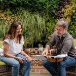 Man and woman discussing over a table with garden plans and material samples for cheap DIY garden path ideas